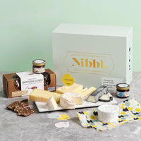 Nibbl Ace Pairings Gifting Cheeseboard containing Cantonnier cheese, Brie, Goat cheese, extra mature cheddar, raincoast crisps crackers, fig, date and maple spread and cranberries and raspberries spread.