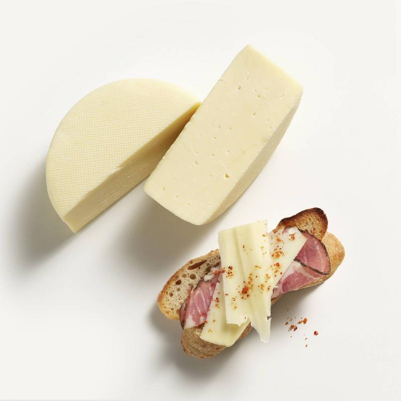 Saputo Friulano Cheese on top of crusty bread and charcuterie
